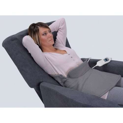 Persona usando la almohadilla eléctrica cervical y hombros Alpak LTK730 en sillón