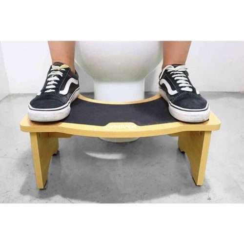 persona usando el taburete para defecar en madera