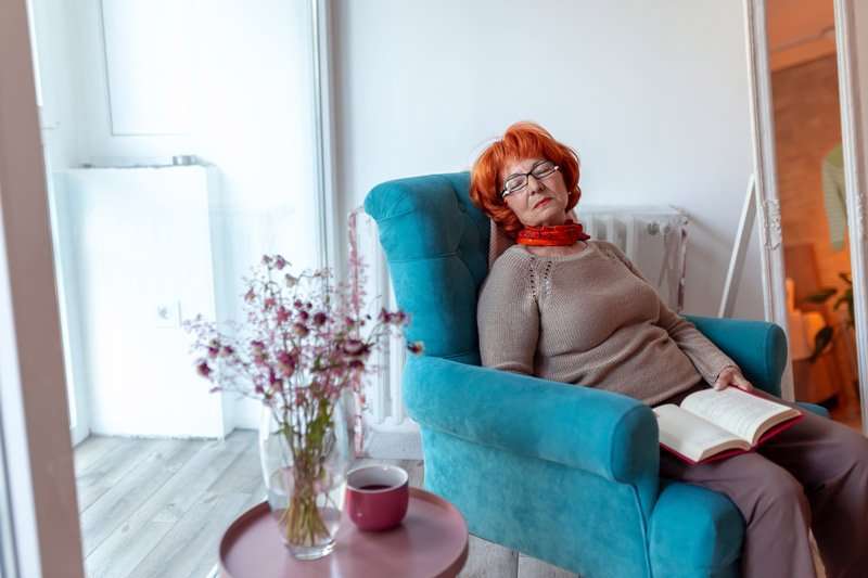 Mujer mayor descansando en sillón relax con respaldo reclinado