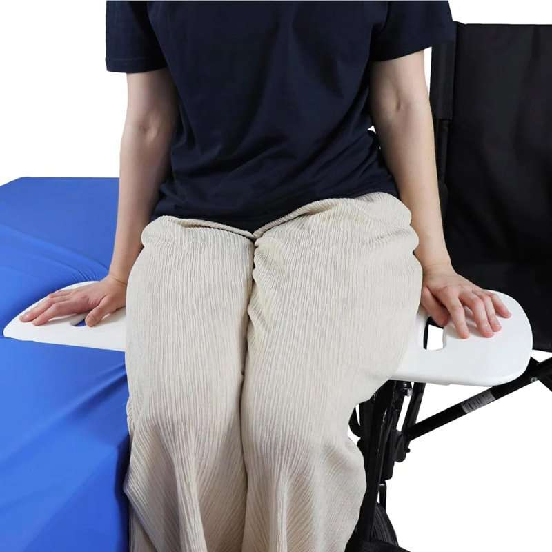 Persona usando la tabla de transferencia Kmina entre silla de ruedas y cama