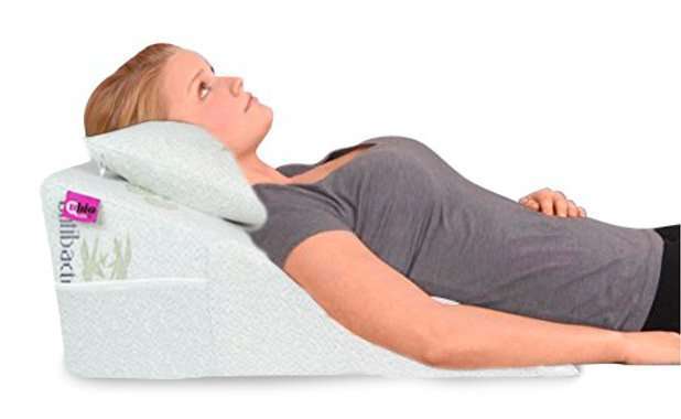Almohada para el reflujo extendida sobre la cama con funda antibacterial