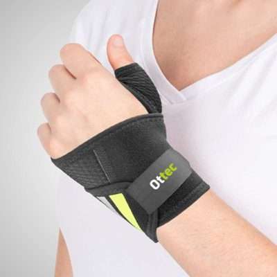Persona con ortesis de muñeca envolvente negra Ottec fijada al pulgar
