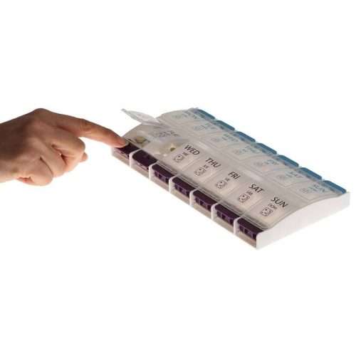 Mano presionando el botón del pastillero para abrir el compartimento diario