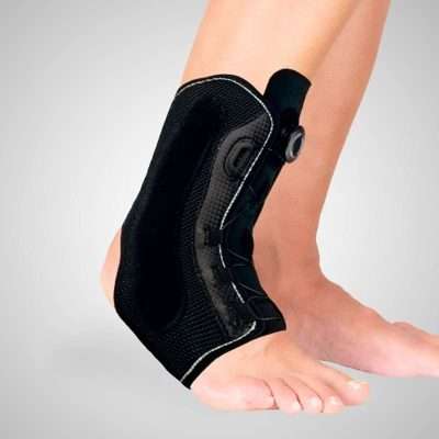 Persona con tobillera estabilizadora Clockfit negra Ottec ajustada en el tobillo