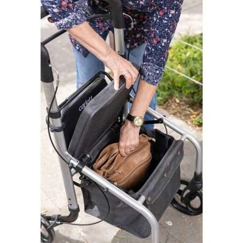 Usuario accediendo a la cesta del andador rollator Lett Go durante un paseo