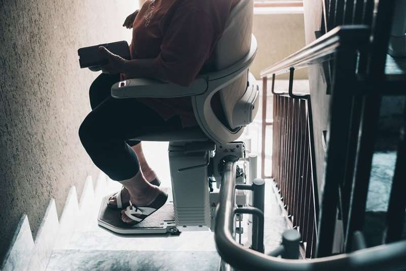Silla salvaescaleras con instalación fija que permite subir y bajar escaleras de forma autónoma y segura