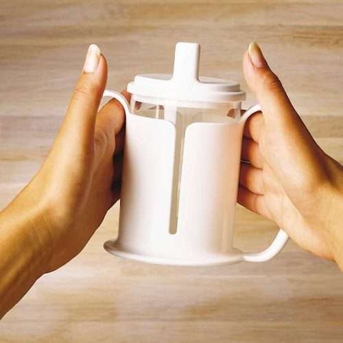 Persona sujetando el vaso adaptado Etac con ambas manos
