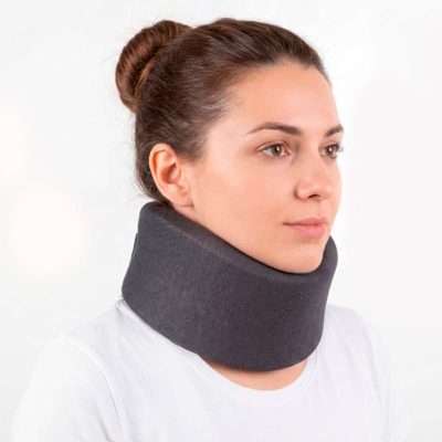 Persona con collarín cervical semirrígido gris colocado en el cuello