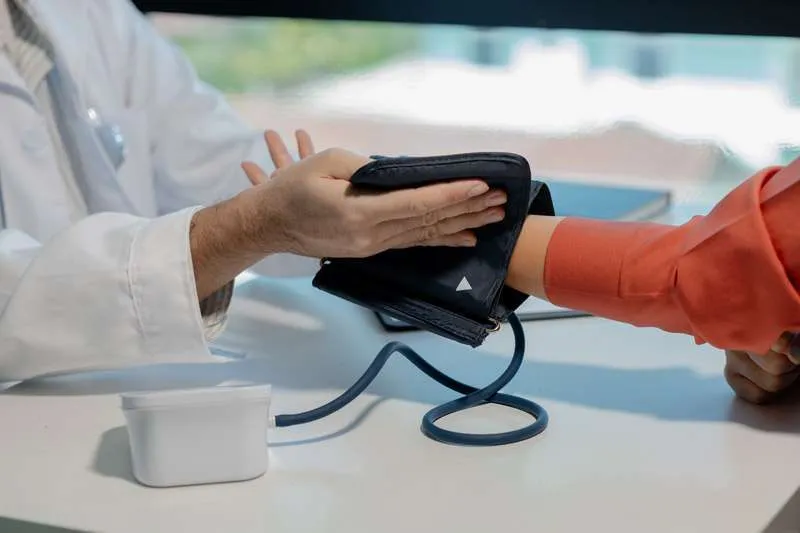 Profesional sanitario colocando el manguito para medir la tensión arterial en el brazo