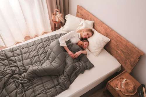 Manta ponderada premium gris colocada sobre la cama