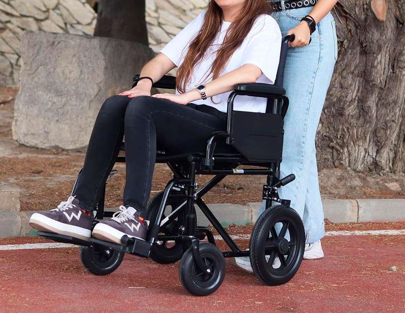Silla de ruedas de tránsito utilizada por acompañante en exterior
