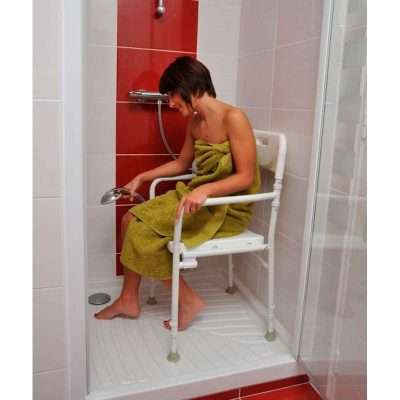 Persona utilizando la silla de ducha plegable Tobago dentro de la ducha