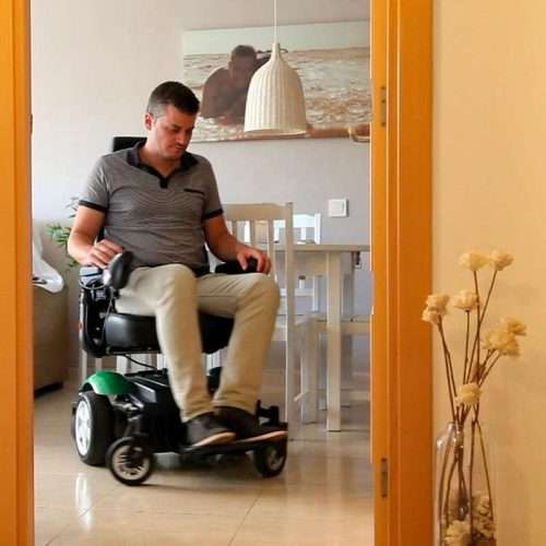 Persona utilizando la silla eléctrica R300 en un espacio interior con paso estrecho