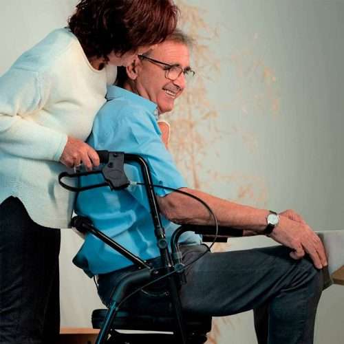 Usuario utilizando el andador y silla de ruedas 2 en 1 con ayuda de un acompañante