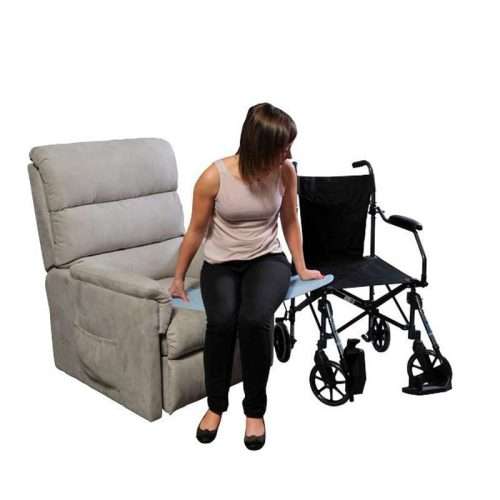 Persona usando una plancha de transferencia entre sillón y silla de ruedas