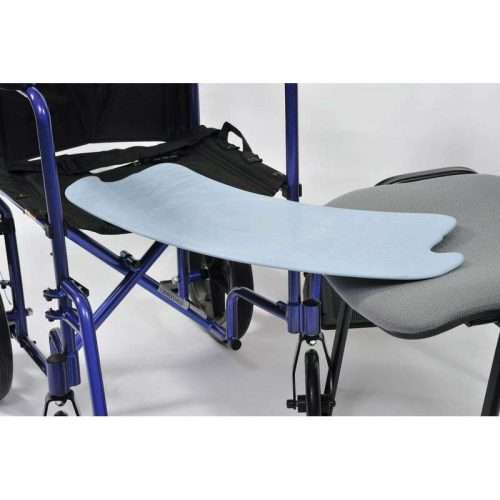 Plancha de transferencia colocada entre silla de ruedas y silla