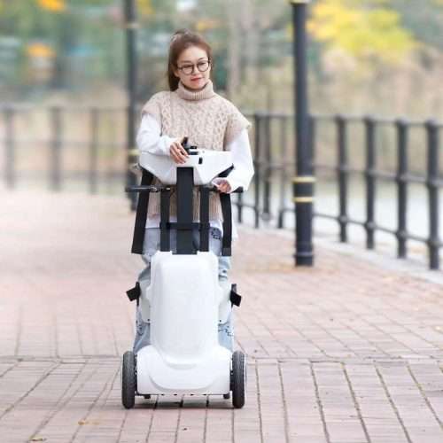 Usuaria disfrutando de un paseo de pie por un parque gracias a la silla de ruedas verticalizadora eléctrica