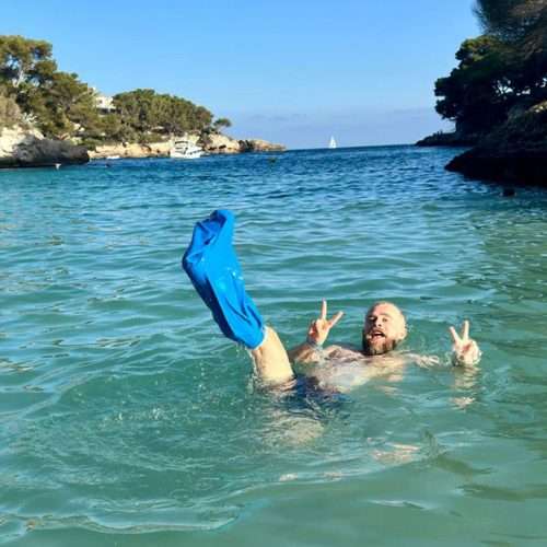Usuario con protector impermeable de escayola para pierna disfrutando de la playa