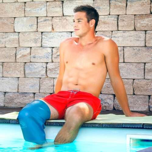 Hombre sentado en el borde de una piscina con protector de rodilla