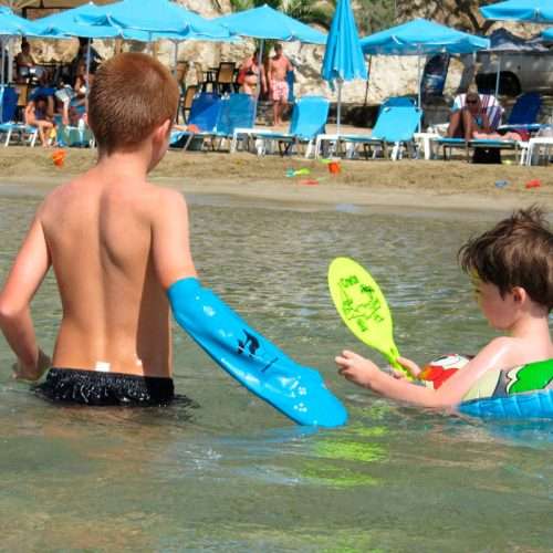 Niño con protector impermeable de brazo en entorno de playa