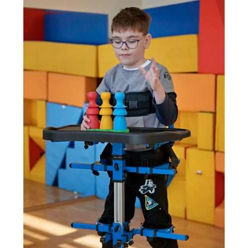 Usuario infantil en el Bipedestador Astride Pro utilizando la mesa durante una actividad
