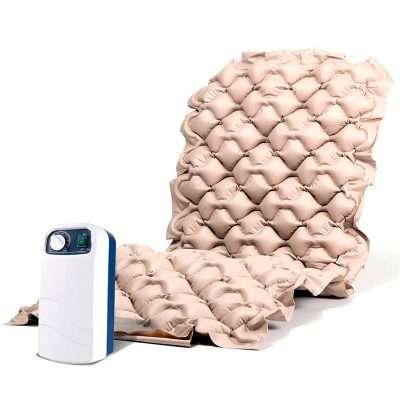 Colchón antiescaras Mat-X1 beige junto al compresor